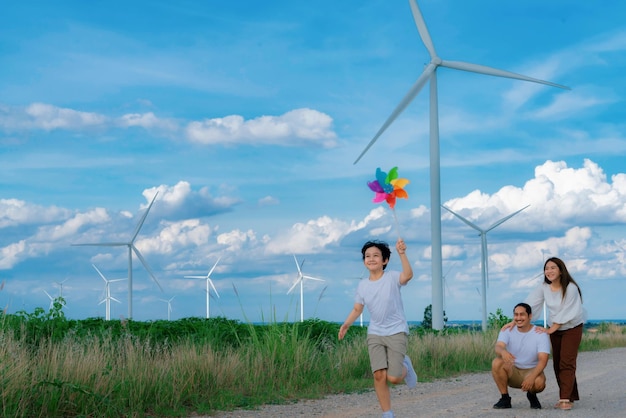 Une famille heureuse progressive profite de son temps au parc éolien pour le concept d'énergie verte