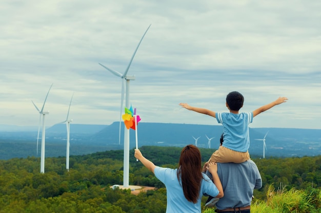 Une famille heureuse progressive profite de son temps au parc éolien pour le concept d'énergie verte