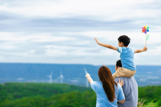 Une famille heureuse progressive profite de son temps au parc éolien pour le concept d'énergie verte
