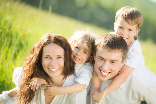 Famille heureuse s'amusant à l'extérieur dans un champ vert de printemps