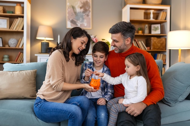 Une famille heureuse s'amusant avec des jouets, des parents et des petits enfants assis ensemble sur le canapé, une famille heureuse assise sur le sofa jouant ensemble, des parents joyeux jouant avec leurs enfants à la maison.