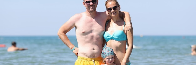 Une famille heureuse s'amuse sur une belle plage chaude et ensoleillée en mer