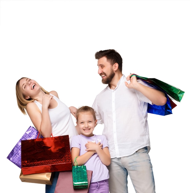 Famille heureuse avec des sacs à provisions debout au studio, isolé sur fond blanc