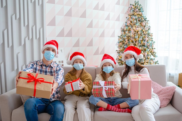 Famille heureuse à Santa Hats pendant les vacances de Noël à la maison pendant une pandémie