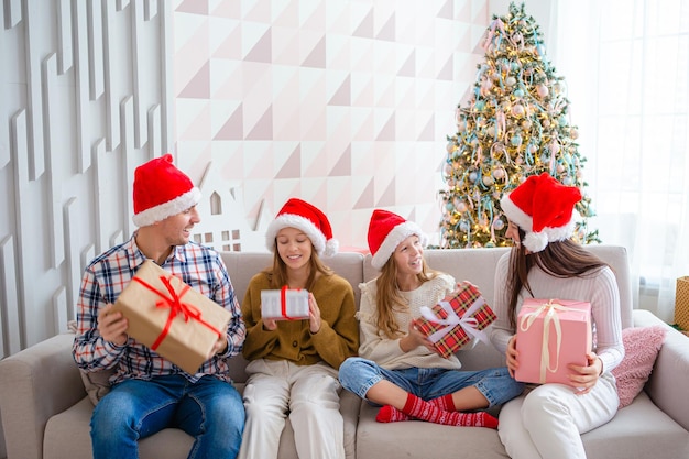 Famille heureuse à Santa Hats pendant les vacances de Noël à la maison