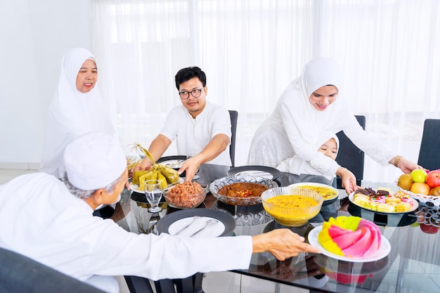 Famille heureuse servant de la nourriture et des boissons ensemble