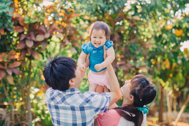 une famille heureuse souriant ensemble dans le jardin.