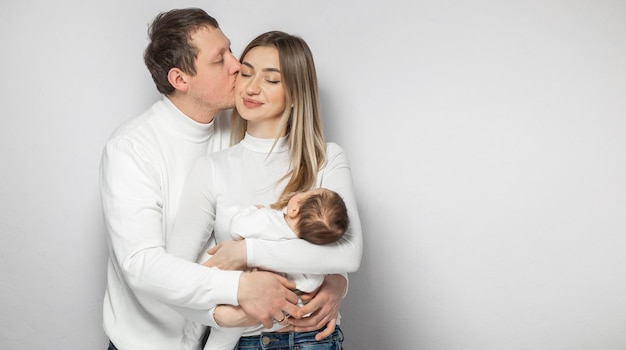 Famille heureuse en studio sur fond blanc