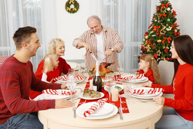 Famille heureuse en train de dîner de Noël dans le salon