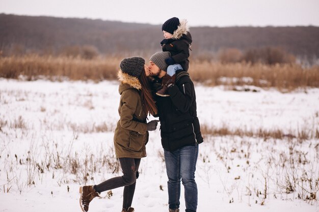 Famille en hiver dans la forêt avec fils