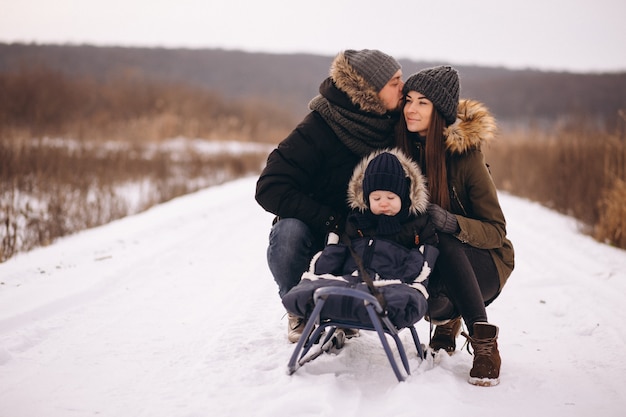 Photo famille en hiver avec des fils de traîneau