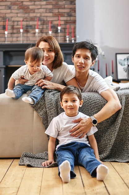 Famille internationale à la maison sur le canapé