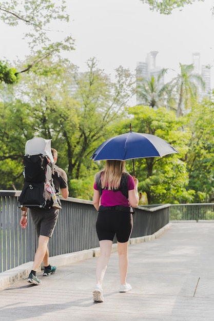 Photo une famille avec de jeunes enfants se promène dans le parc avec un parapluie