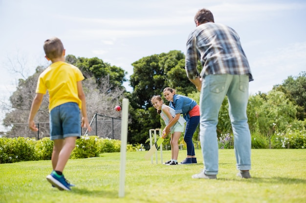 Photo famille jouant au cricket dans le parc