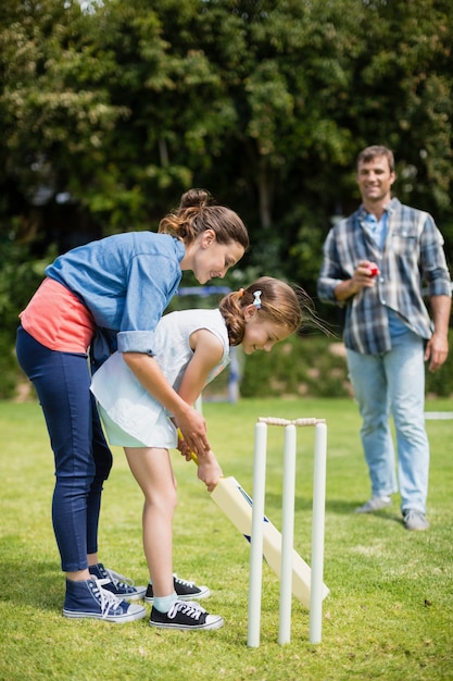 Famille jouant au cricket dans le parc