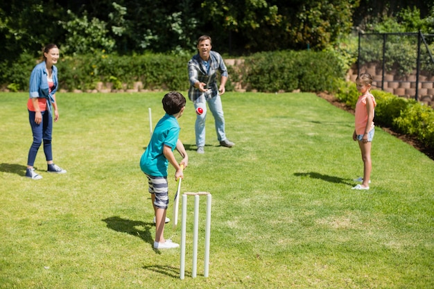 Famille jouant au cricket dans le parc