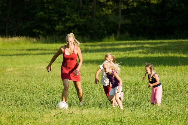 Famille Jouant Au Football Dans Un Terrain En Herbe