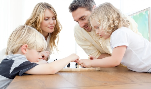 Photo famille jouant aux échecs sur une table