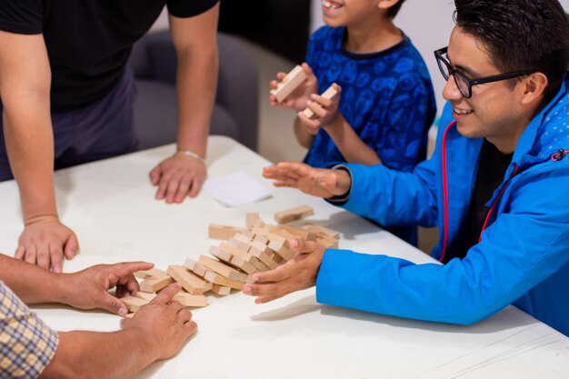 Famille jouant ensemble jeu de blocs à la maison