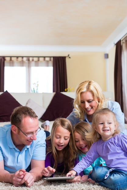 Famille jouant avec une tablette à la maison