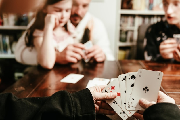 Photo la famille joue aux cartes le soir.