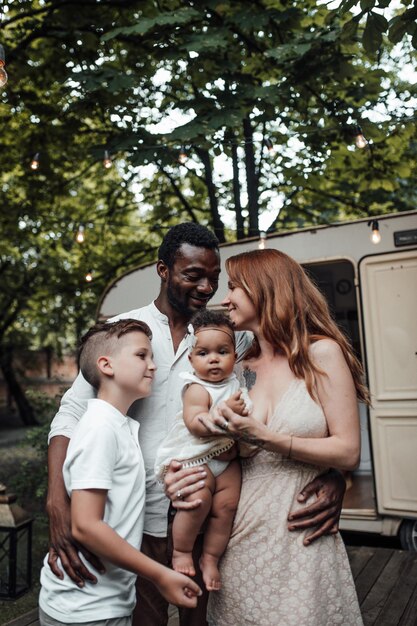 Photo une famille joyeuse debout contre une fourgonnette à l'extérieur