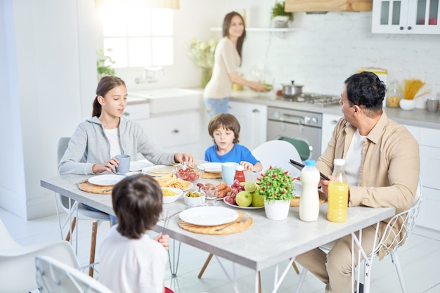 Famille latine en train de dîner ensemble à la maison femme servant un repas pour son mari et