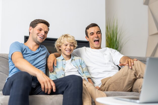 Famille LGBT, couple gay avec fils adoptif - Parents homosexuels avec leur enfant s'amusant à la maison