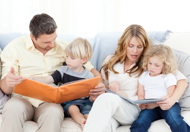 Famille lisant un livre sur leur canapé