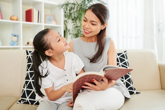 Famille lisant un livre à la maison