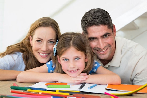 Famille avec livre et crayons assis à table