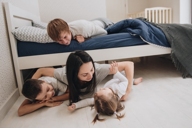 Famille à la maison en pyjama. Fille et fils. Réveillez-vous le matin. Embrassant et embrassant dans la chambre sur le lit.