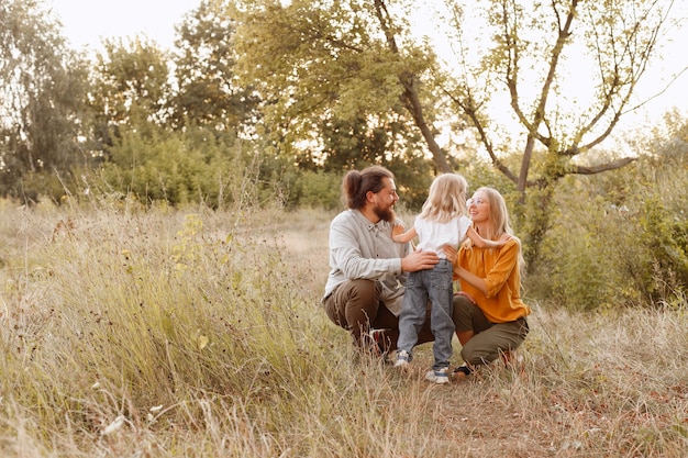 Famille maman papa fille sur une promenade ensemble heureux