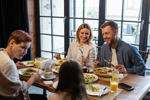 Famille mangeant ensemble à l'intérieur