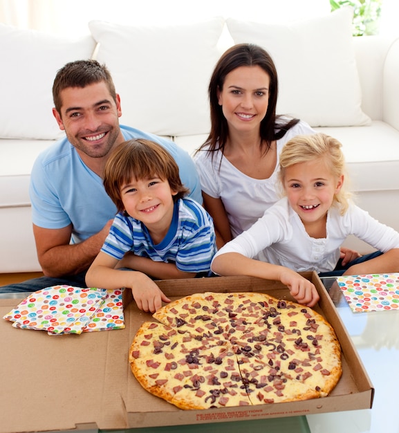 Famille, manger de la pizza sur le canapé