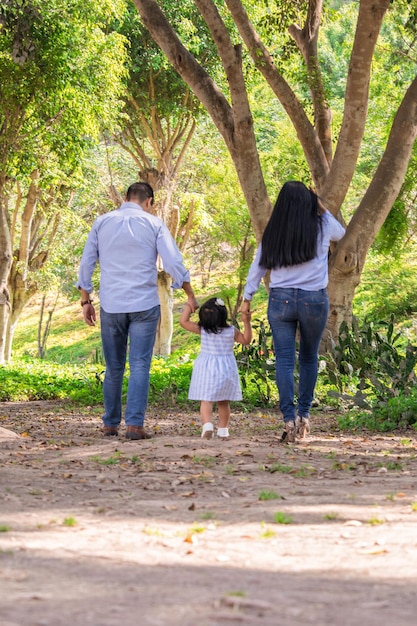 Famille marchant main dans la main dans un parc au Pérou