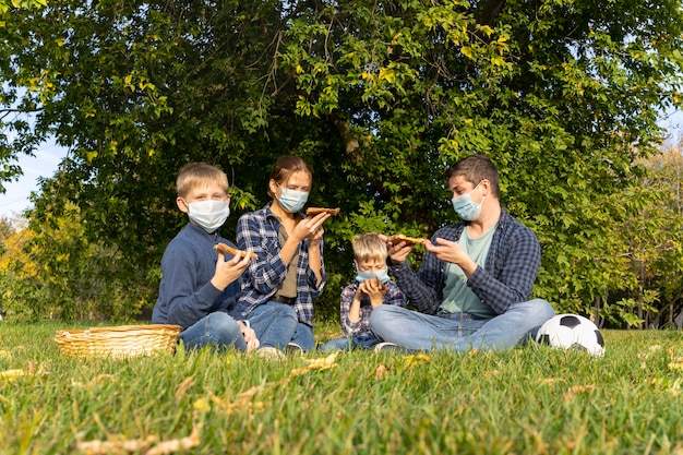 Une famille avec des masques de protection dans le parc