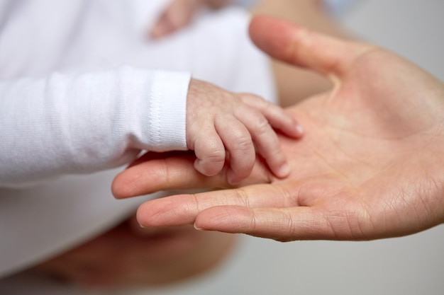 famille, maternité, parentalité, personnes et concept de garde d'enfants - gros plan des mains de la mère et du nouveau-né