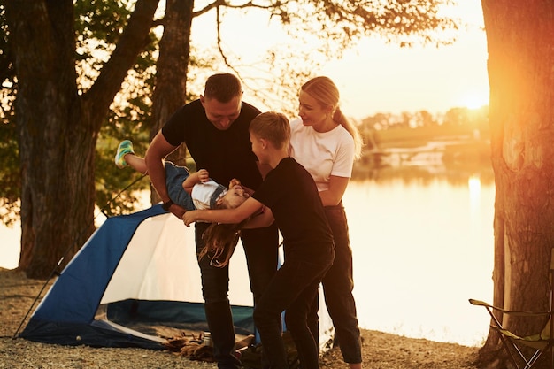 La famille de la mère, du père et des enfants est au camping