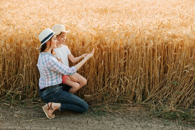 La famille mère et fille d'agriculteurs touchent les oreilles avec leurs mains contrôlent la qualité de l'oreille...