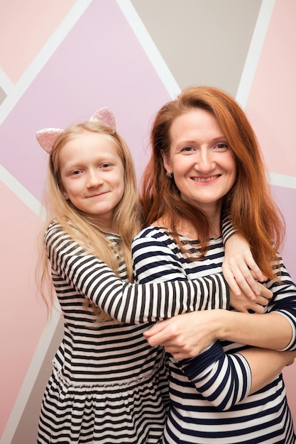 Famille - mère et fille heureuses regardent la caméra