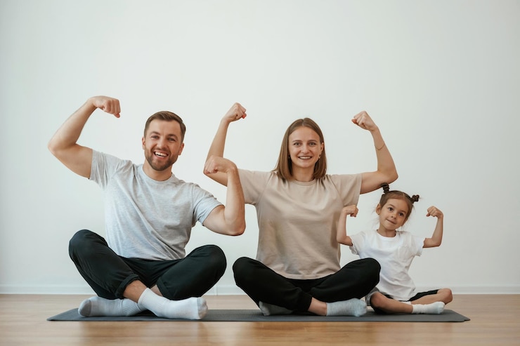 Photo la famille de la mère, le père et la fille font du yoga à la maison.
