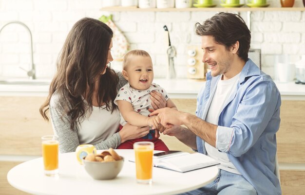 Famille millénaire appréciant le matin ensemble à la cuisine à la maison