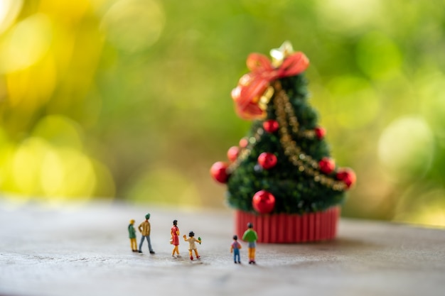 Famille Miniature gens debout sur un arbre de Noël Célébrez Noël