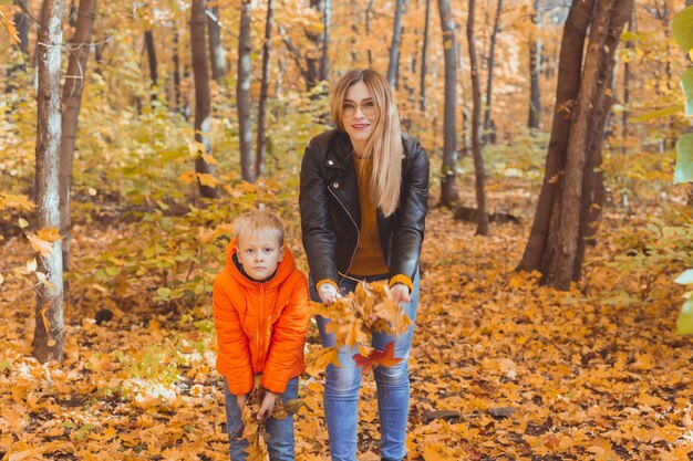 Famille Monoparentale Jouant Avec Des Feuilles D'automne Dans Le Parc Maman Et Fils Heureux Jettent Des Feuilles D'automne Dans