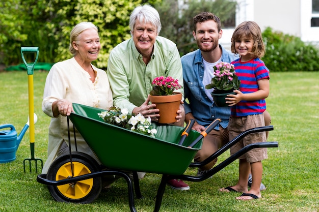 Famille multi génération avec outils de jardinage dans la cour