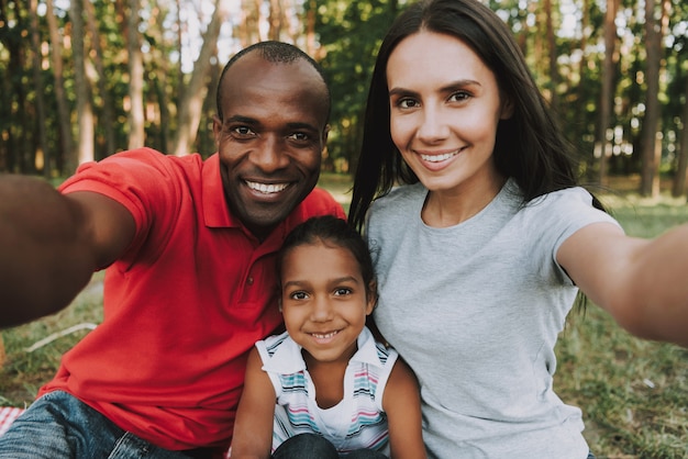 Famille multinationale faisant un selfie sur un pique-nique.