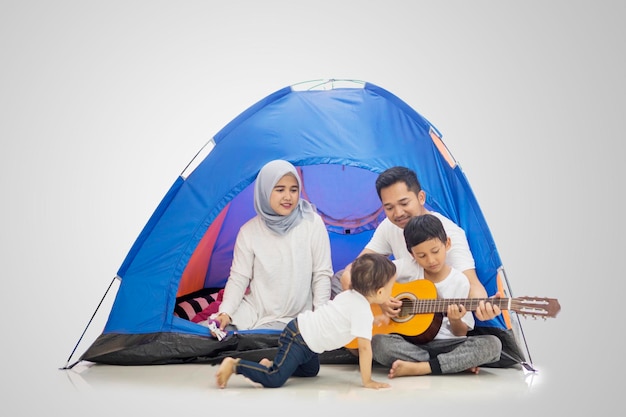 Famille musulmane chantant dans la tente avec guitare