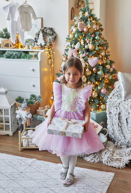 Famille de Noël Enfant fille sur fond d'arbre de Noël