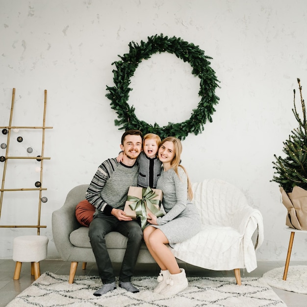 Famille de Noël étreignant L'enfant a surpris sa mère et son père avec un cadeau de Noël Coffret cadeau ouvert pour la famille Joyeux Noël et joyeuses fêtes Bonne année 2021